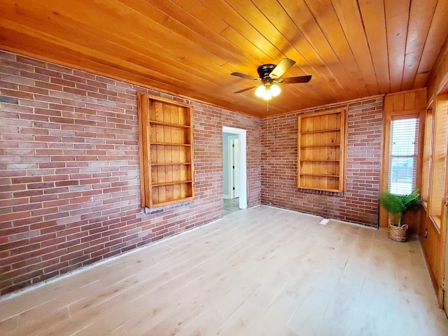 spare room with built in shelves, a ceiling fan, brick wall, light wood-style floors, and wooden ceiling