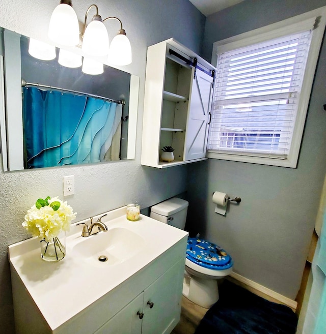 full bath with baseboards, toilet, a textured wall, a notable chandelier, and vanity