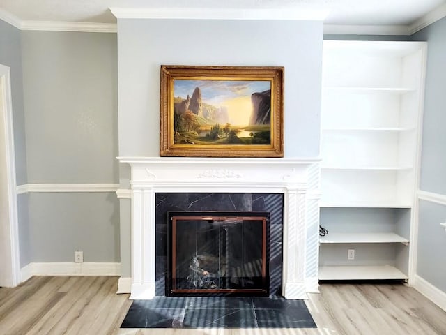 room details with a fireplace, crown molding, and wood finished floors