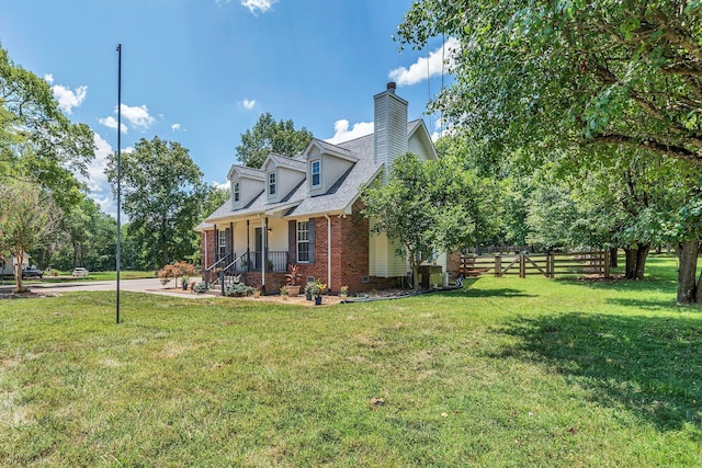 view of side of property featuring fence, a yard, a shingled roof, brick siding, and a chimney