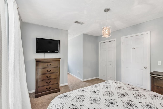 carpeted bedroom featuring visible vents, baseboards, and a closet