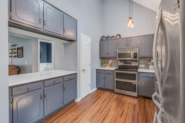 kitchen featuring wood finished floors, appliances with stainless steel finishes, and gray cabinetry