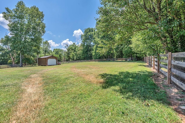 view of yard with a garage, a storage shed, an outdoor structure, and fence