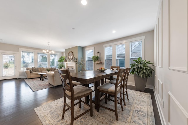 dining area with recessed lighting, a notable chandelier, a healthy amount of sunlight, and wood finished floors