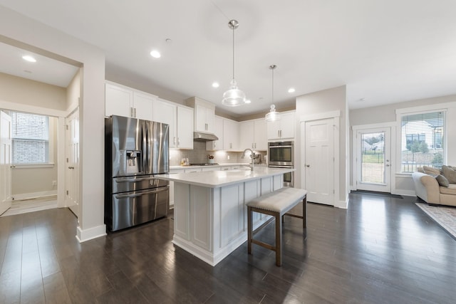 kitchen featuring tasteful backsplash, dark wood-style floors, white cabinetry, appliances with stainless steel finishes, and light countertops