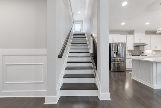 stairs with visible vents, recessed lighting, wood finished floors, and baseboards