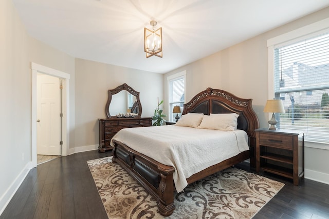 bedroom featuring baseboards, a notable chandelier, and dark wood-style floors