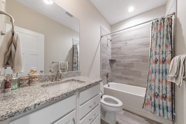 full bathroom featuring visible vents, toilet, wood finished floors, vanity, and shower / bathtub combination with curtain