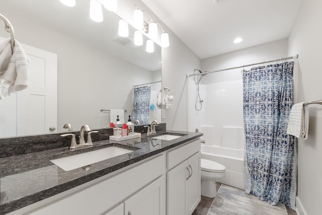 full bath featuring shower / bath combination with curtain, toilet, double vanity, and a sink