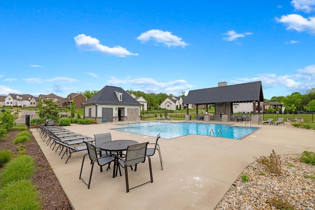 community pool featuring a gazebo, fence, an outdoor structure, and a patio area