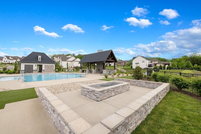 community pool featuring fence, a residential view, an outdoor fire pit, a gazebo, and a patio