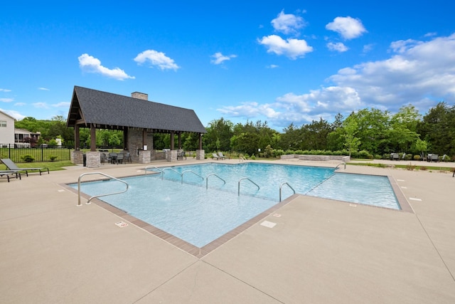 pool with a gazebo, a patio, and fence