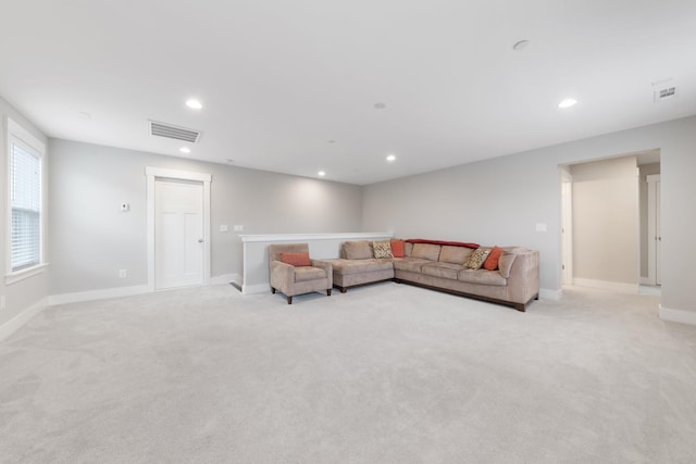 living area featuring recessed lighting, visible vents, baseboards, and light carpet