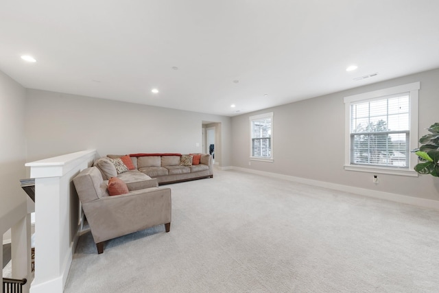 living room with light carpet, plenty of natural light, and baseboards