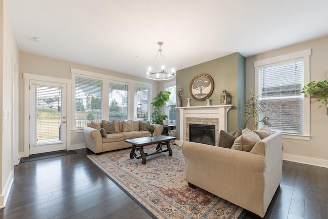 living room with baseboards, a notable chandelier, dark wood finished floors, and a fireplace