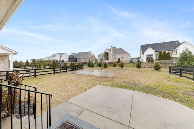 view of yard with a patio area, a residential view, and a fenced backyard