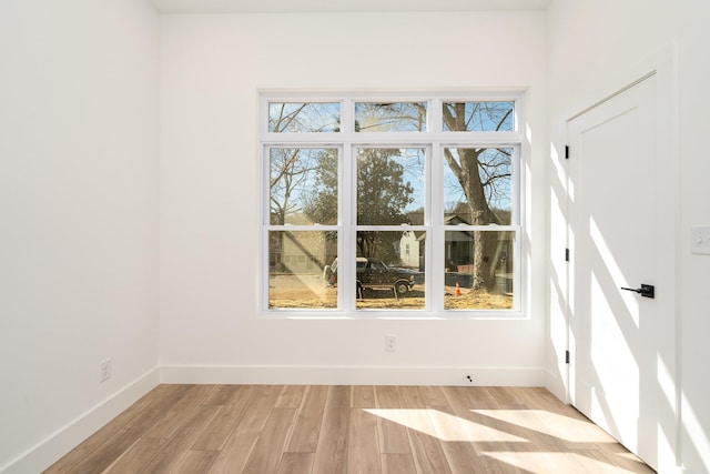 empty room with baseboards and light wood-style floors