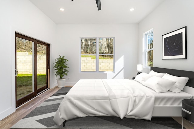 bedroom with a ceiling fan, wood finished floors, baseboards, recessed lighting, and access to outside