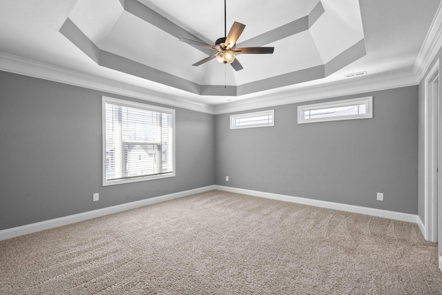 carpeted empty room featuring a raised ceiling, baseboards, and visible vents