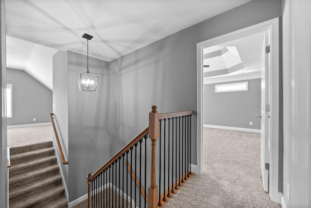 stairway featuring lofted ceiling, carpet flooring, baseboards, and a chandelier