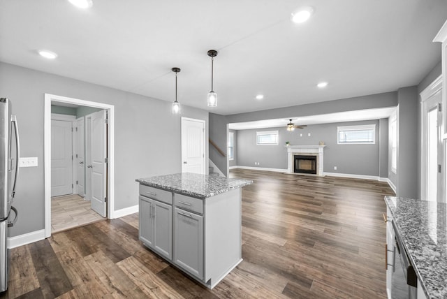 kitchen with a fireplace with flush hearth, dark wood-style floors, baseboards, and gray cabinetry