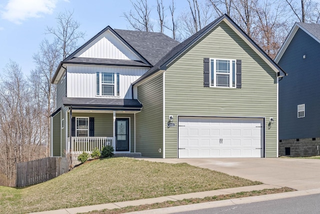 traditional-style house with a front yard, roof with shingles, an attached garage, covered porch, and concrete driveway