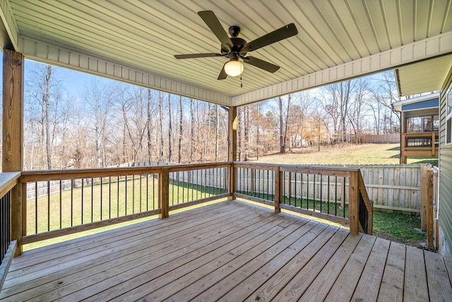 wooden terrace featuring a lawn, a ceiling fan, and fence