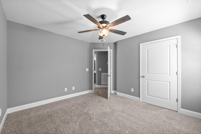 unfurnished bedroom with carpet flooring, visible vents, a ceiling fan, and baseboards