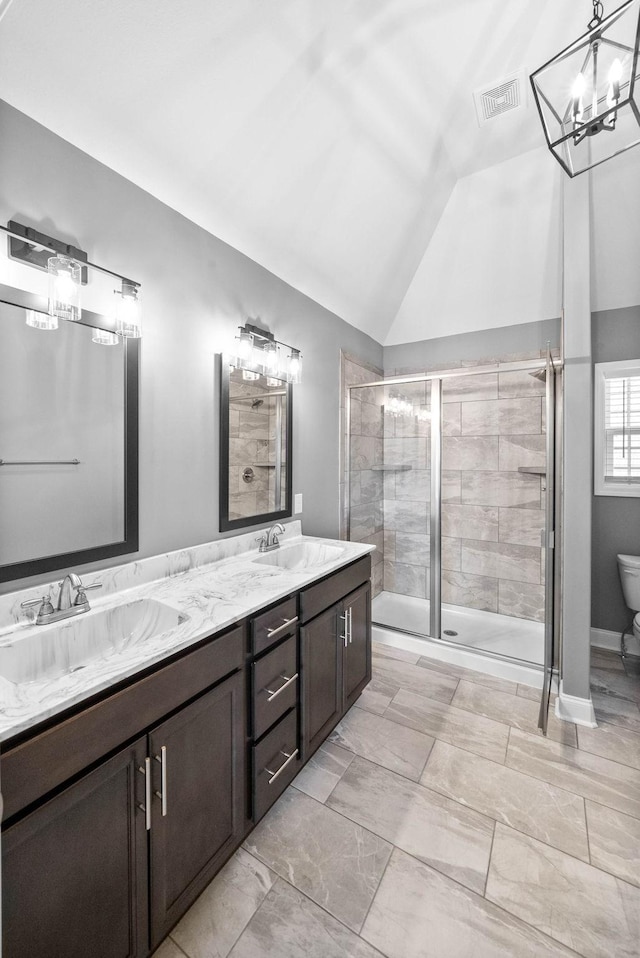 full bath with a sink, lofted ceiling, toilet, and a stall shower