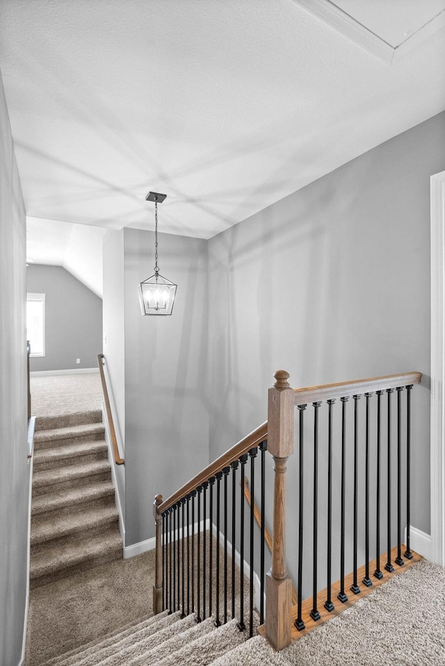 stairway featuring vaulted ceiling, carpet flooring, and baseboards