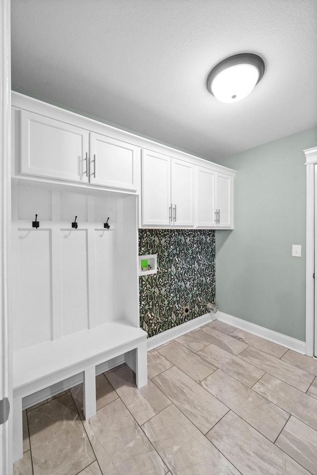 mudroom with baseboards and a textured ceiling