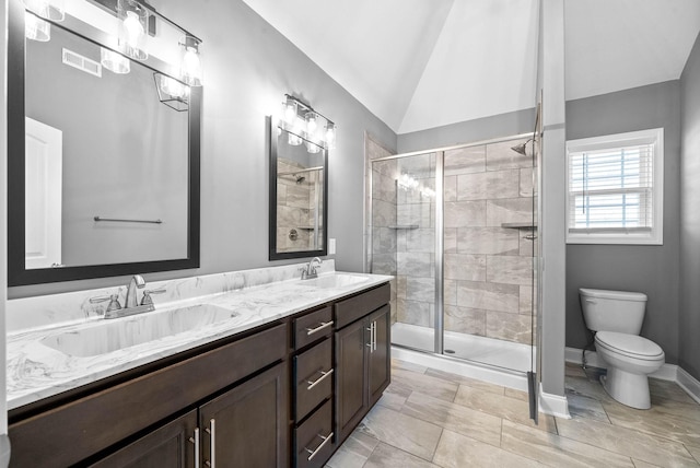 full bath with double vanity, a stall shower, lofted ceiling, and a sink