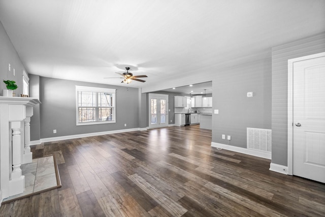 unfurnished living room featuring dark wood finished floors, a fireplace, visible vents, and baseboards