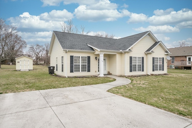 view of front facade with an outbuilding, a storage shed, a front lawn, and a shingled roof