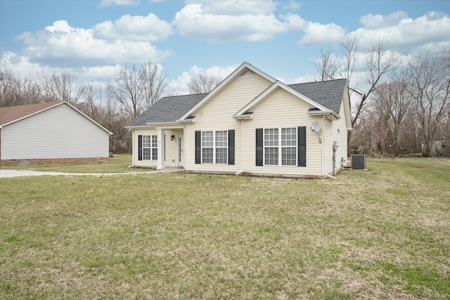 view of front facade with roof with shingles, central AC unit, and a front yard