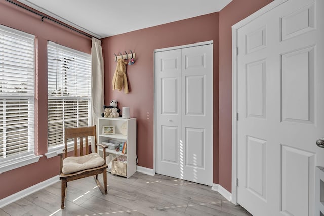 living area with light wood-style flooring and baseboards