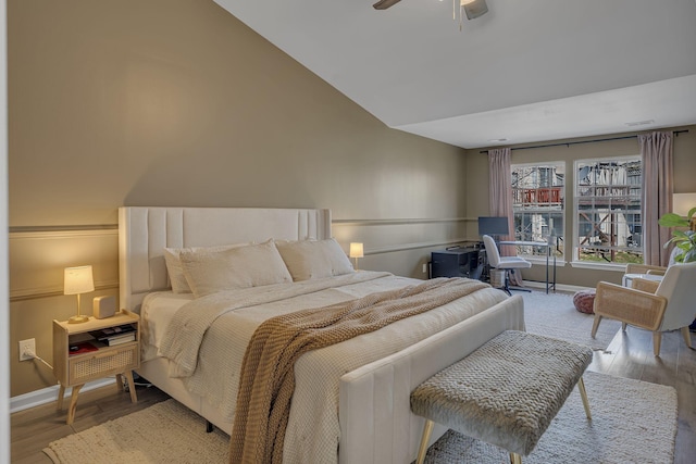 bedroom with baseboards, wood finished floors, and vaulted ceiling