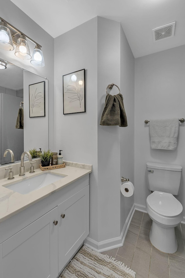 bathroom featuring visible vents, toilet, tile patterned flooring, baseboards, and vanity