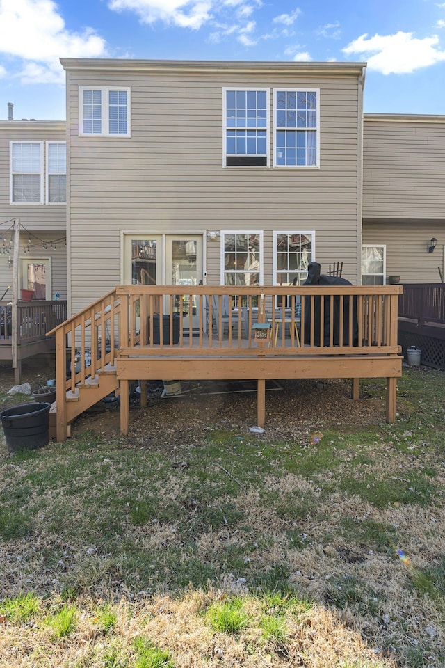 back of house featuring a deck and a yard