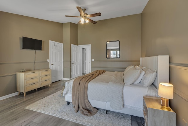 bedroom featuring vaulted ceiling, wood finished floors, baseboards, and ceiling fan