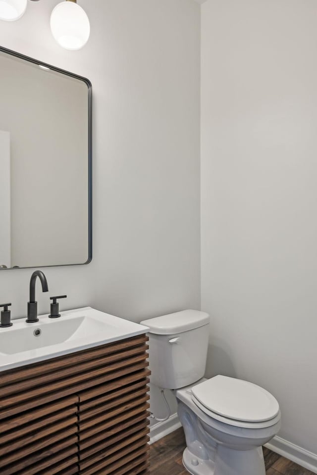 bathroom featuring toilet, baseboards, and wood finished floors