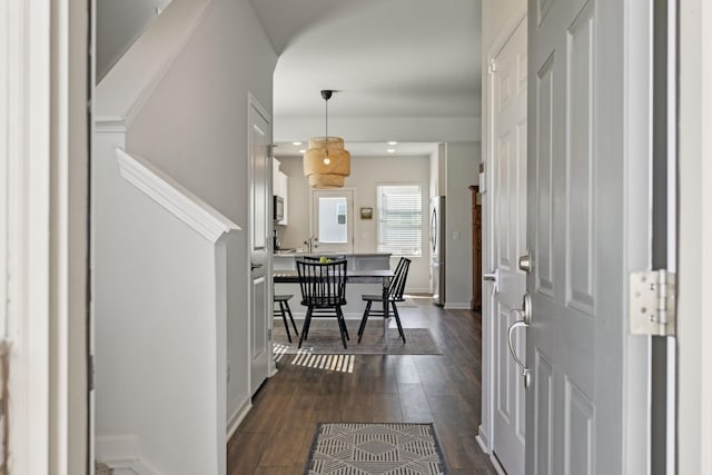 foyer with dark wood-type flooring and baseboards