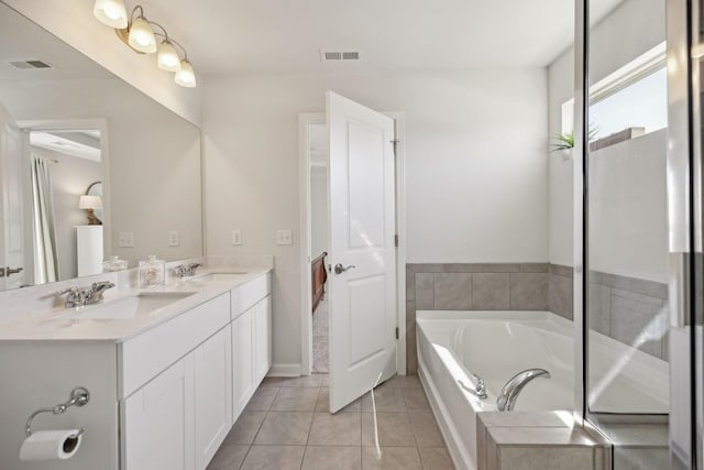 bathroom with tile patterned floors, double vanity, visible vents, and a sink