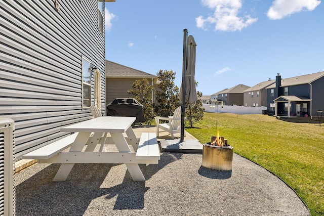 view of yard featuring a patio area, a residential view, a fire pit, and fence