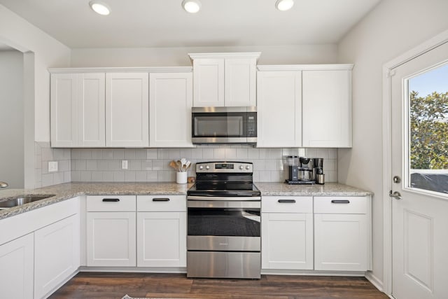 kitchen with a sink, stainless steel appliances, white cabinets, and decorative backsplash