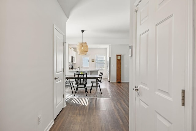 hall with baseboards and dark wood-style flooring