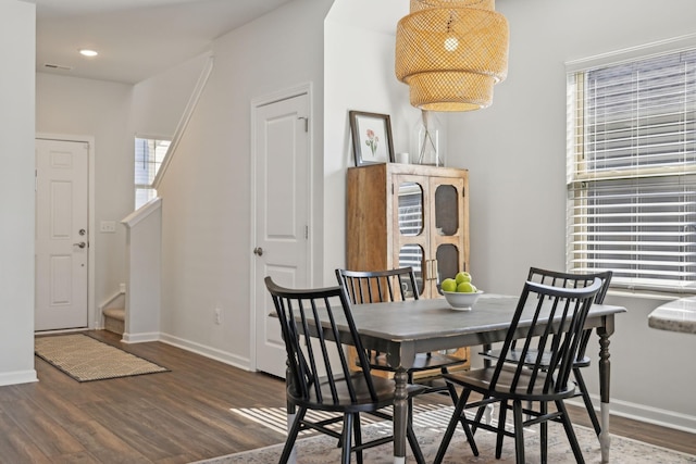 dining area featuring stairs, baseboards, and wood finished floors