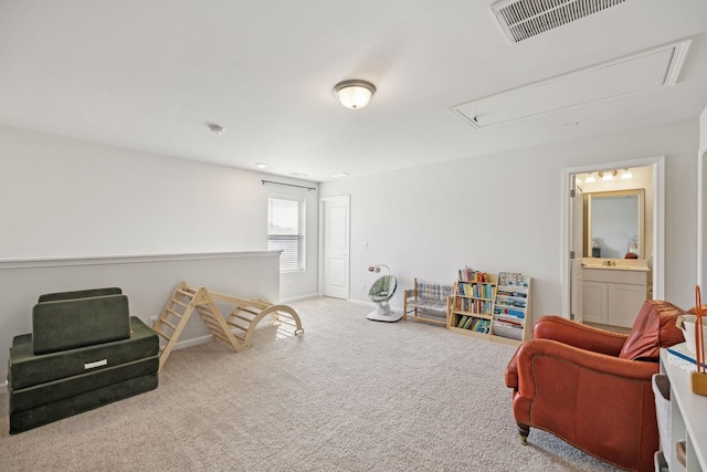 sitting room with visible vents, carpet floors, and attic access