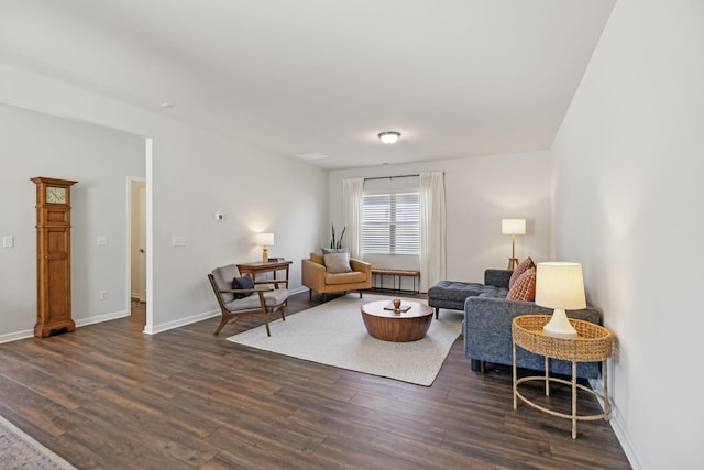 living area featuring baseboards and dark wood finished floors