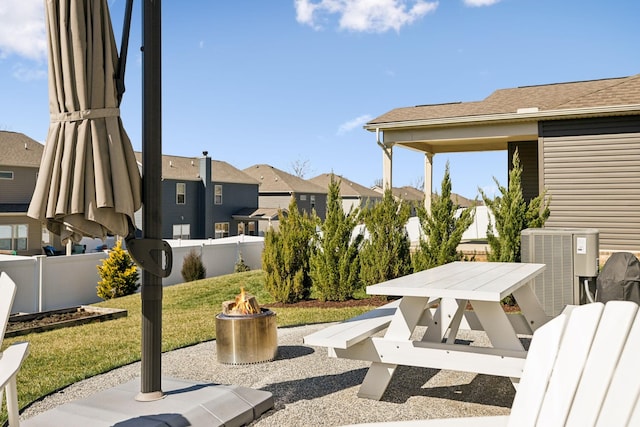 view of patio featuring cooling unit, a residential view, a fire pit, and fence